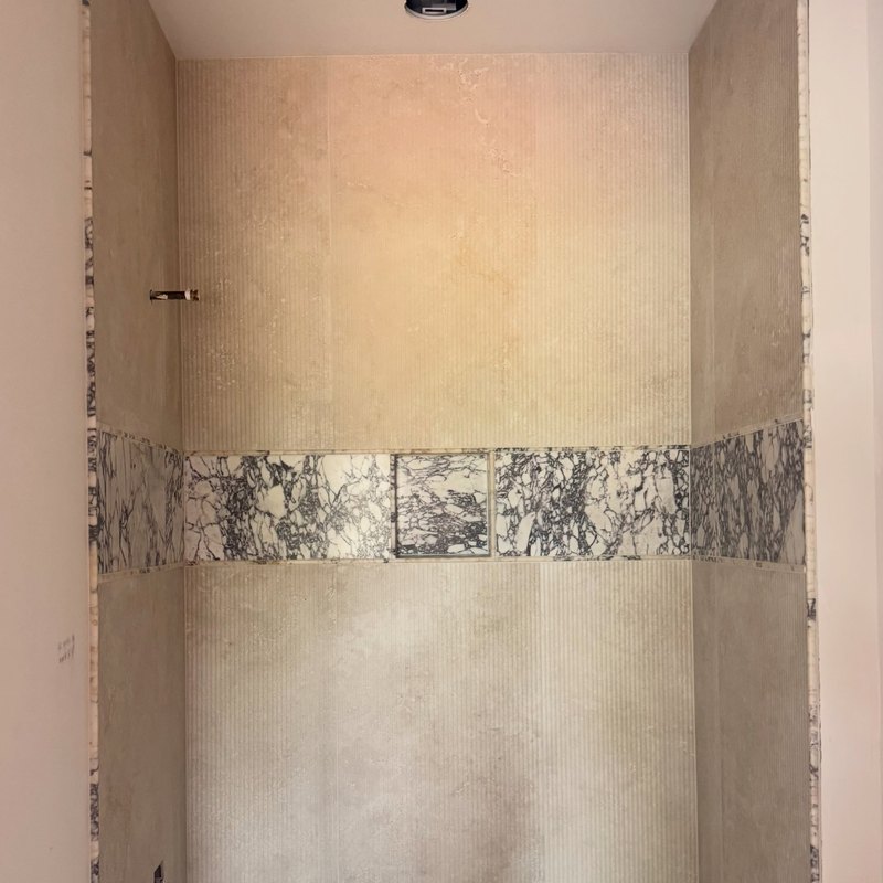 Plaster alcove with a horizontal band of veined marble set into it.