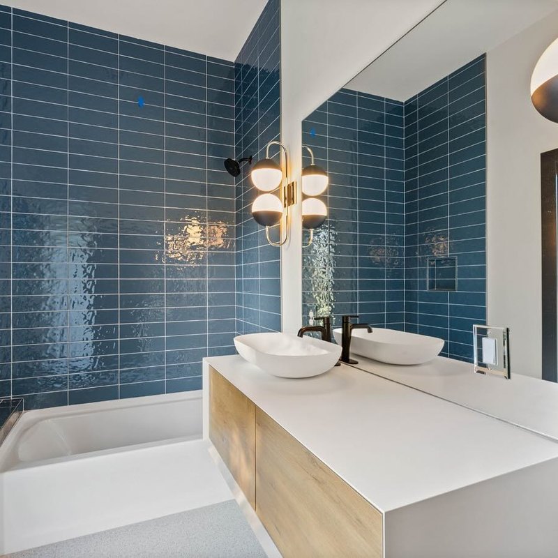 Blue vertical stack tile behind a floating oak vanity with two vessel basins.